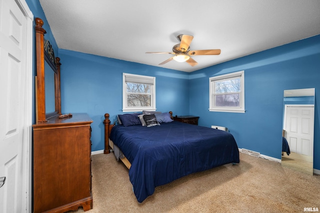 bedroom featuring carpet, multiple windows, visible vents, and baseboards