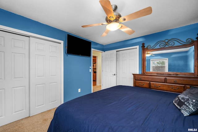 bedroom featuring two closets, carpet, and a ceiling fan