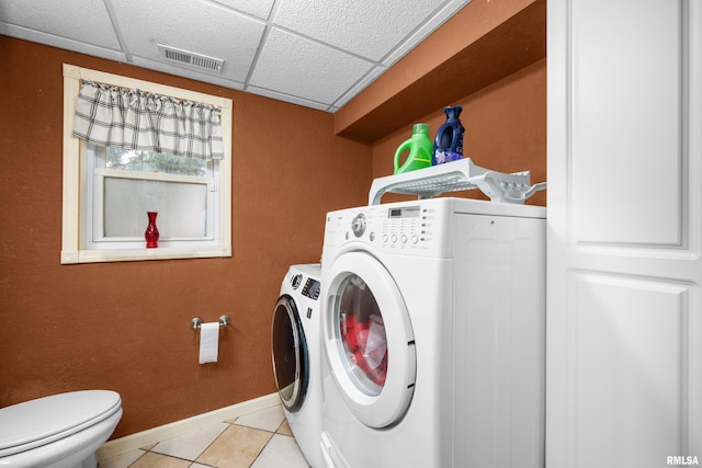 laundry area with light tile patterned floors, visible vents, washer and dryer, laundry area, and baseboards