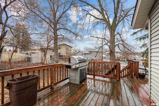 wooden terrace featuring a residential view, a fenced backyard, and a grill