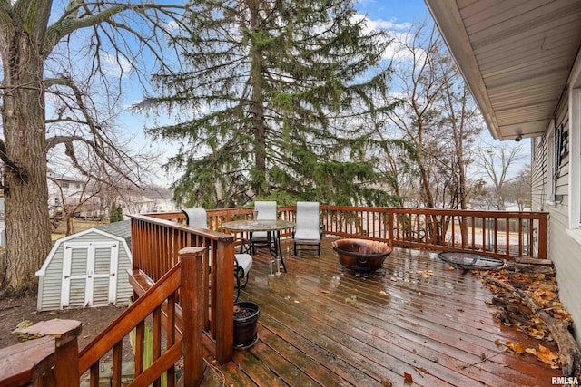 wooden deck featuring a shed and an outdoor structure