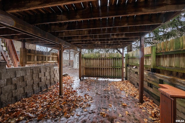 view of patio with an outbuilding, a fenced backyard, and a storage shed