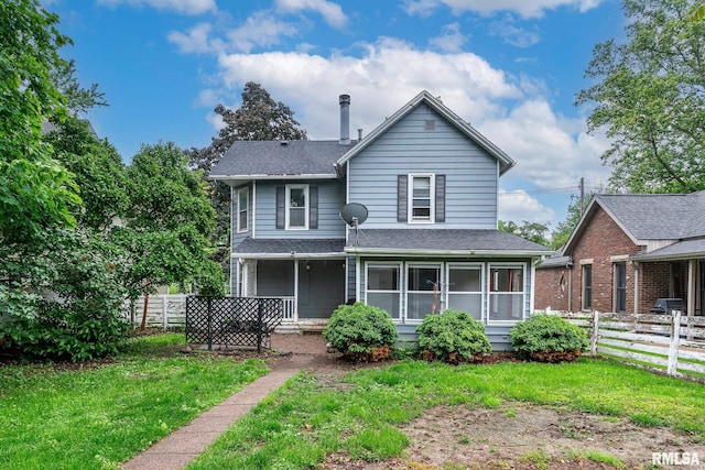 view of front of house with a front lawn, roof with shingles, and fence