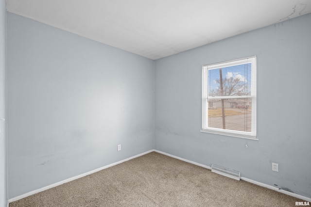 carpeted spare room with visible vents and baseboards