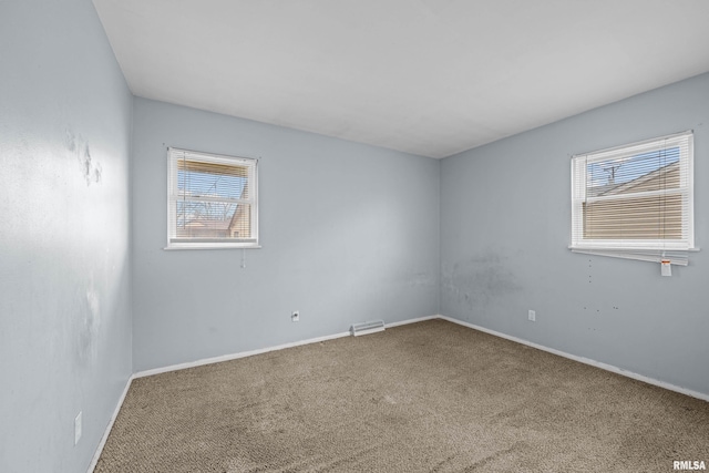 carpeted spare room featuring visible vents and baseboards