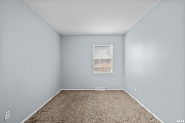 carpeted spare room with visible vents and baseboards