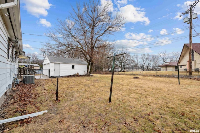 view of yard featuring fence, central AC, and an outdoor structure