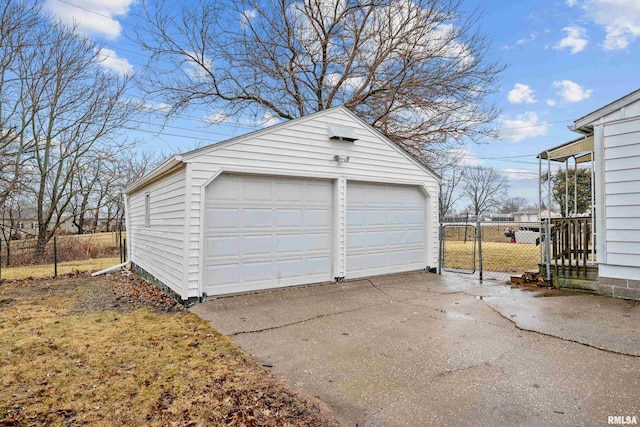 detached garage featuring fence and a gate