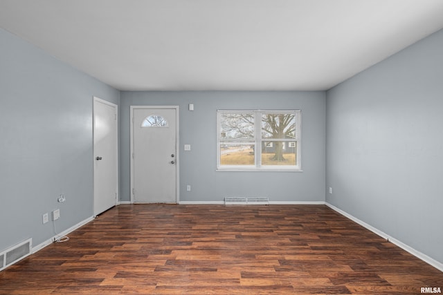 foyer entrance featuring visible vents, baseboards, and wood finished floors