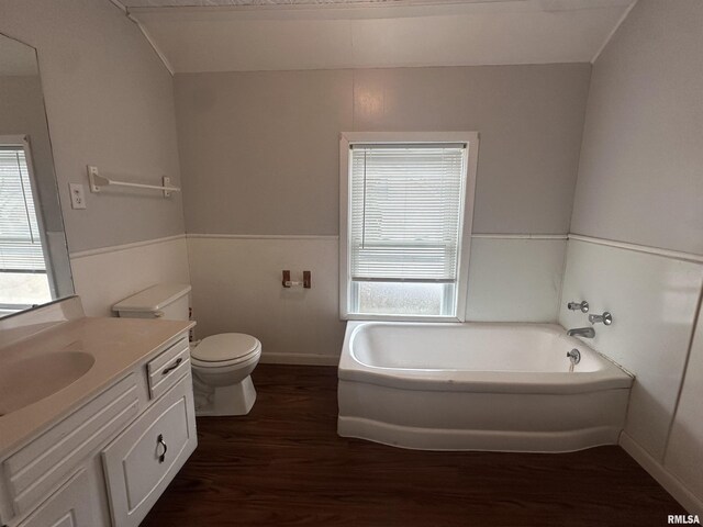 full bath featuring a wealth of natural light, a garden tub, vanity, and wood finished floors