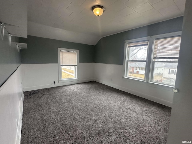 spare room with lofted ceiling, carpet flooring, and baseboards