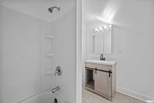 bathroom with lofted ceiling, tile patterned flooring, vanity, baseboards, and shower / washtub combination