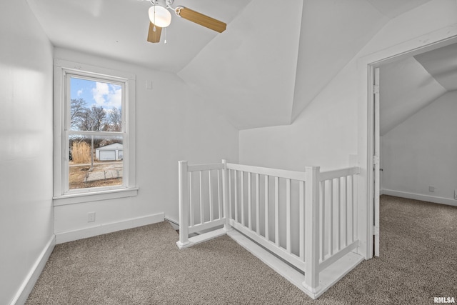 additional living space with vaulted ceiling, carpet, a ceiling fan, and baseboards