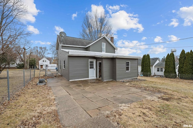 view of front of home with a chimney, a gate, a patio area, fence, and driveway