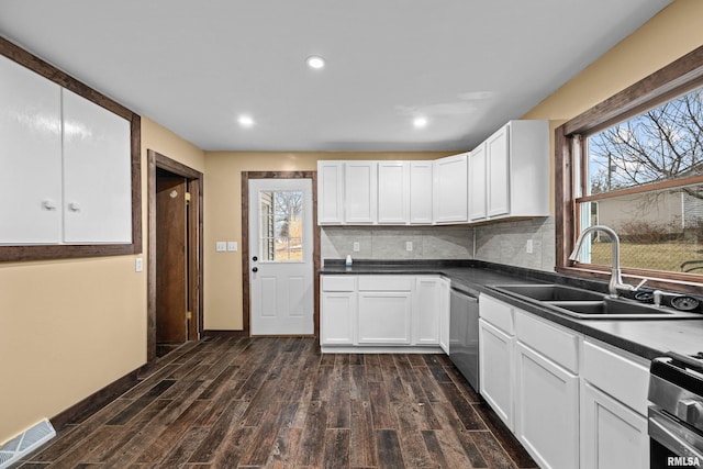 kitchen with stove, visible vents, stainless steel dishwasher, decorative backsplash, and dark countertops