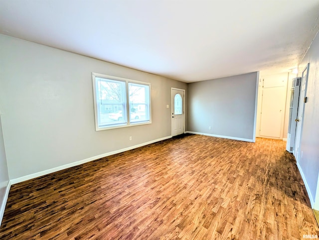 empty room featuring baseboards and wood finished floors