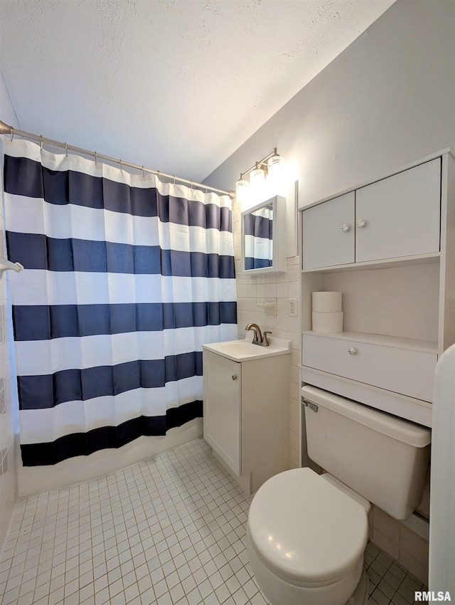 bathroom featuring a textured ceiling, vanity, toilet, and tile patterned floors