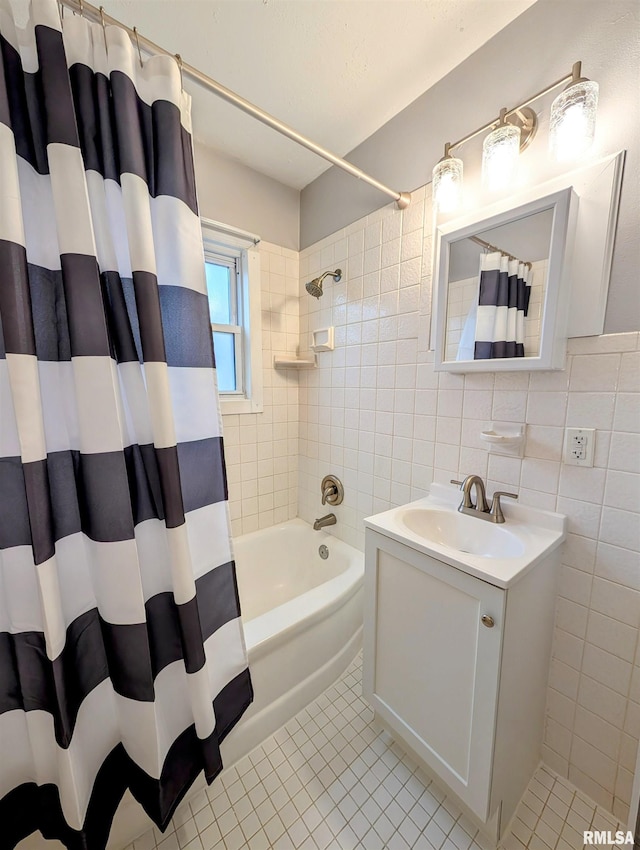 full bath with tile patterned flooring, shower / tub combo with curtain, tile walls, and vanity