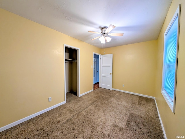 unfurnished bedroom with ceiling fan, a closet, carpet, and baseboards