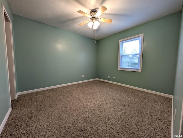 empty room featuring carpet floors, ceiling fan, and baseboards