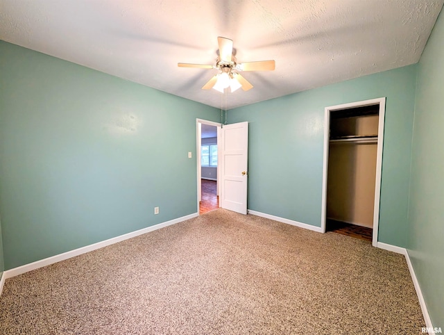 unfurnished bedroom with carpet, a textured ceiling, baseboards, and a closet