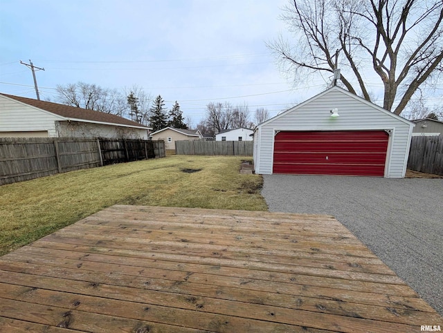 wooden deck with an outbuilding, a fenced backyard, a yard, and a detached garage