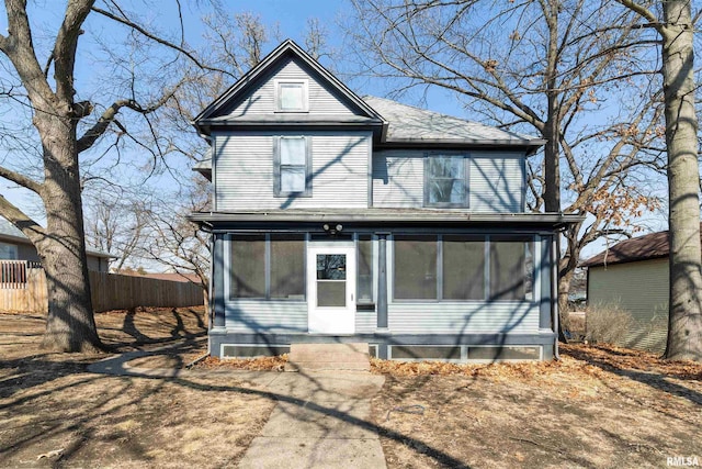 view of front facade featuring a sunroom and fence