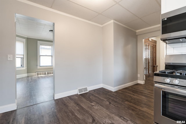 kitchen with appliances with stainless steel finishes, dark wood-style flooring, visible vents, and ornamental molding