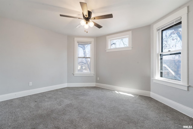 carpeted empty room with ceiling fan and baseboards