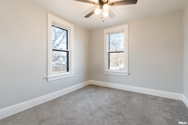 carpeted spare room with baseboards, a ceiling fan, and a healthy amount of sunlight