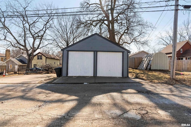 detached garage featuring fence