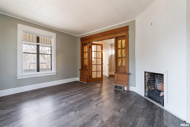 unfurnished living room with dark wood-style floors, baseboards, visible vents, and crown molding