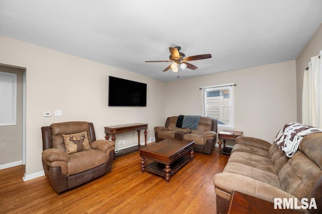 living area with ceiling fan, light wood finished floors, and baseboards