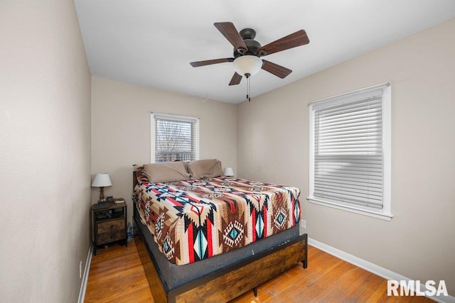 bedroom with a ceiling fan, baseboards, and wood finished floors