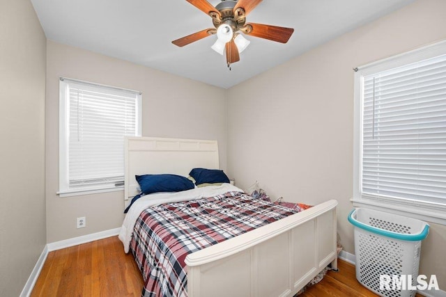 bedroom featuring ceiling fan, baseboards, and wood finished floors