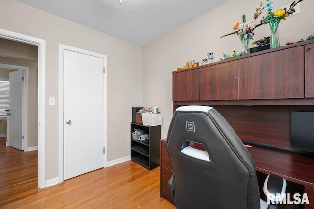 office space with baseboards and light wood finished floors