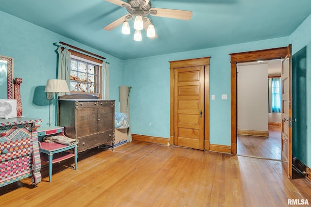 bedroom with hardwood / wood-style flooring, ceiling fan, and baseboards