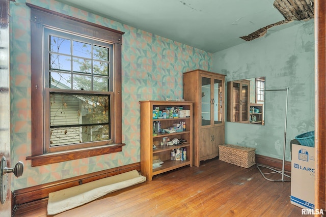 interior space with wood-type flooring, baseboards, and wallpapered walls