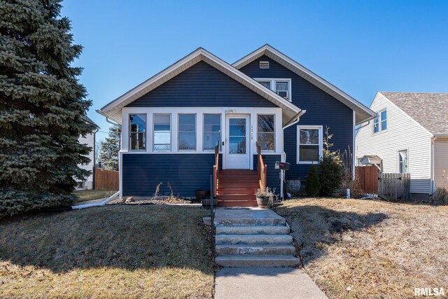 bungalow-style home with fence, a front lawn, and entry steps