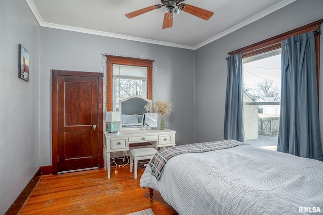 bedroom with crown molding, multiple windows, and wood finished floors