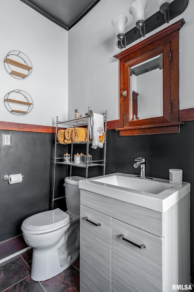 half bathroom with vanity, toilet, and tile patterned floors