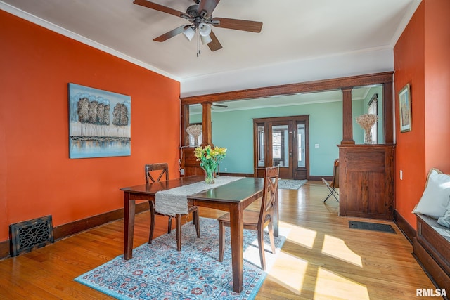 dining room with baseboards, ornamental molding, ceiling fan, and wood finished floors