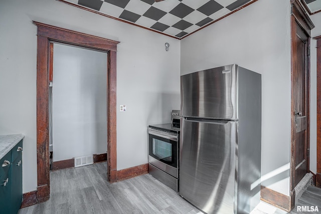 kitchen with light wood finished floors, stainless steel appliances, light countertops, visible vents, and baseboards