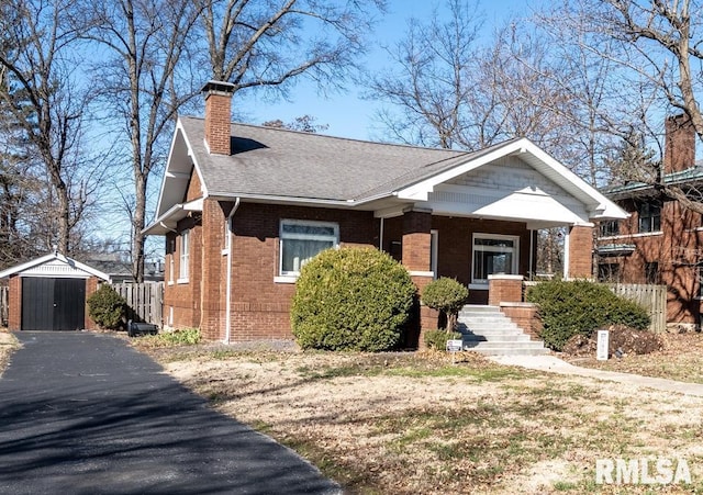 view of front of house featuring brick siding, a shingled roof, an outdoor structure, a storage unit, and a chimney