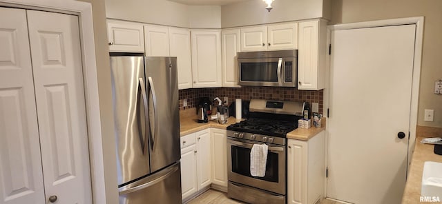 kitchen with white cabinets, appliances with stainless steel finishes, and light countertops