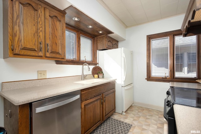 kitchen with electric range, light countertops, stainless steel dishwasher, light floors, and a sink