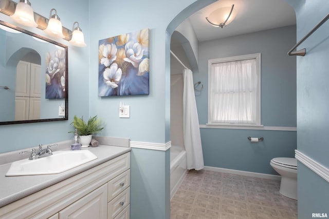 bathroom featuring shower / bathtub combination with curtain, toilet, vanity, baseboards, and tile patterned floors