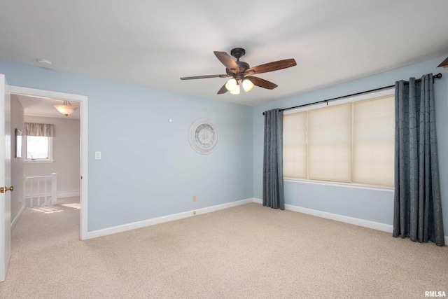 empty room with a ceiling fan, carpet flooring, and baseboards