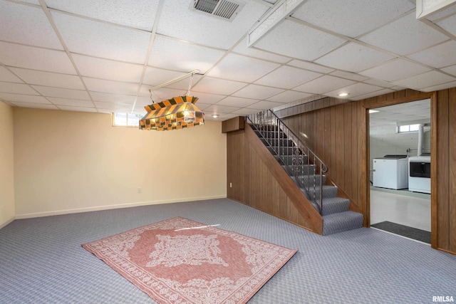 basement featuring wooden walls, carpet flooring, visible vents, washer and dryer, and stairs