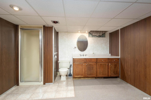 full bathroom featuring a stall shower, wood walls, vanity, and toilet